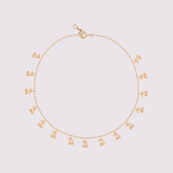 Delicate 22K gold anklet with small charms on a white background